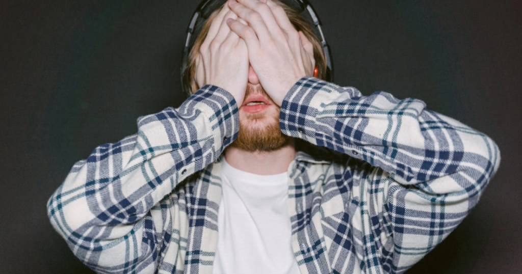 Tired gamer with hand on face. Energy supplements fail by the second hour and this gamer is visibly crashing hard